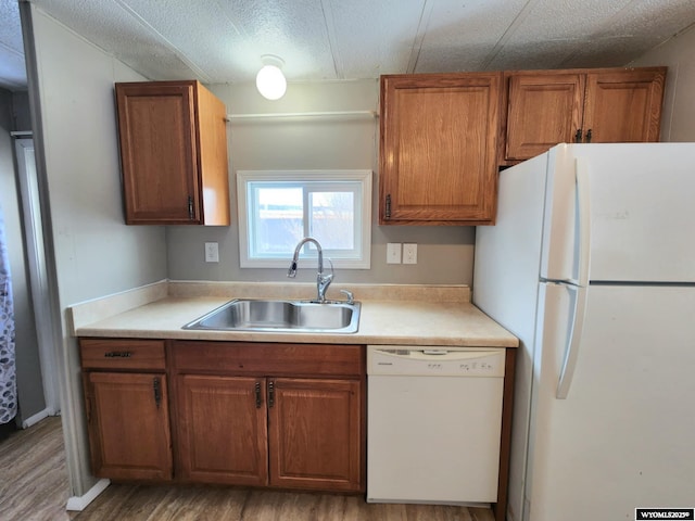 kitchen featuring white appliances, light hardwood / wood-style flooring, and sink