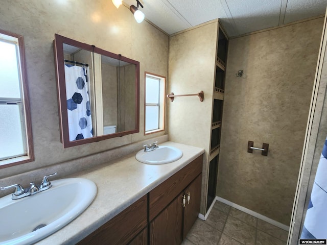 bathroom featuring tile patterned floors, plenty of natural light, vanity, and a textured ceiling