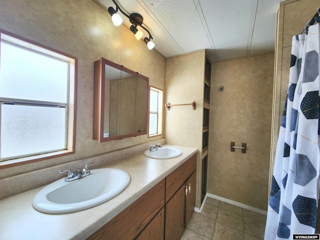 bathroom with tile patterned flooring, vanity, a textured ceiling, and walk in shower