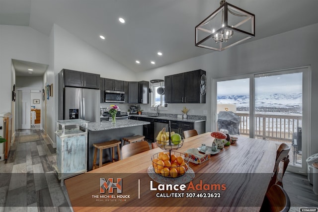 dining space with light wood finished floors, high vaulted ceiling, a chandelier, and recessed lighting