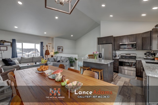 dining space with high vaulted ceiling, light wood finished floors, and recessed lighting