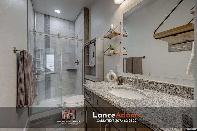 bathroom with a stall shower, vanity, and toilet