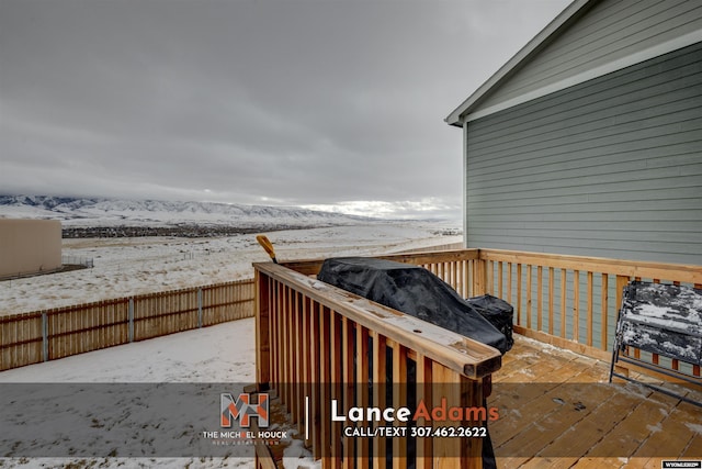 snow covered deck featuring a mountain view