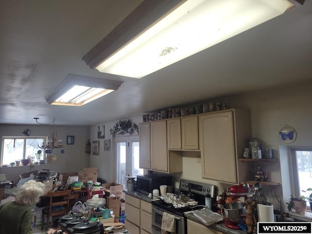 kitchen featuring stainless steel appliances, dark countertops, and open floor plan