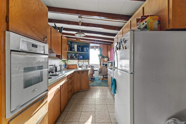 kitchen with white refrigerator, stainless steel oven, light tile patterned floors, cooktop, and beam ceiling