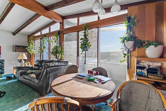 carpeted dining space with lofted ceiling with beams and a healthy amount of sunlight