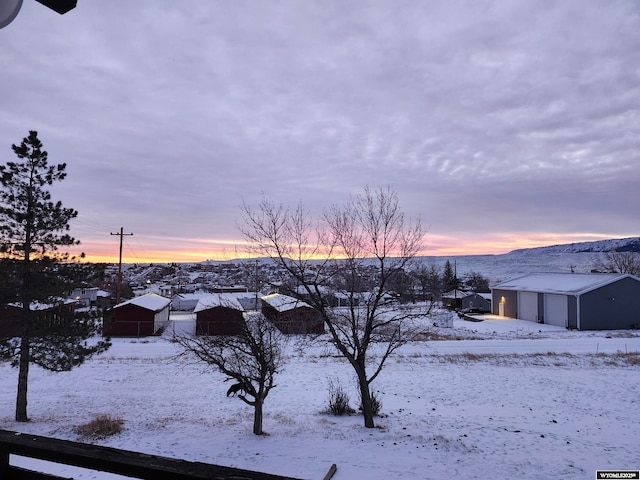 yard covered in snow with an outbuilding