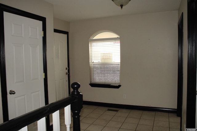spare room featuring baseboards and light tile patterned floors