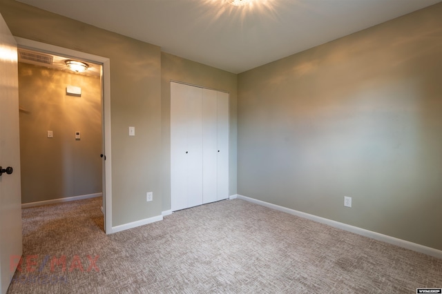 unfurnished bedroom with carpet flooring and a closet