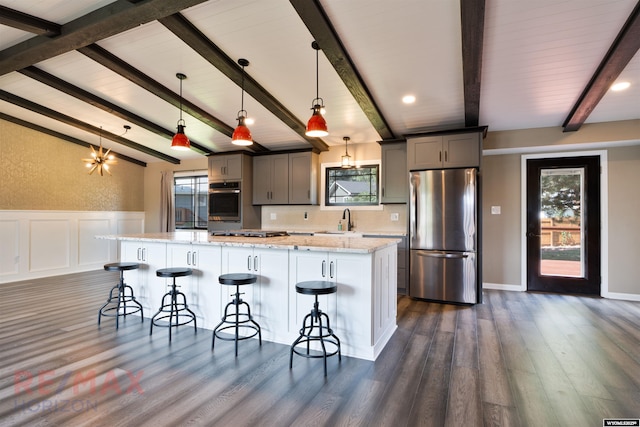 kitchen featuring a large island, stainless steel appliances, a kitchen breakfast bar, pendant lighting, and gray cabinets