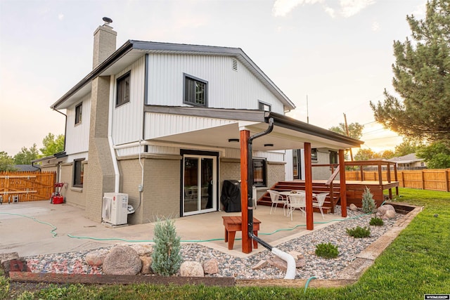 rear view of property featuring ac unit and a patio