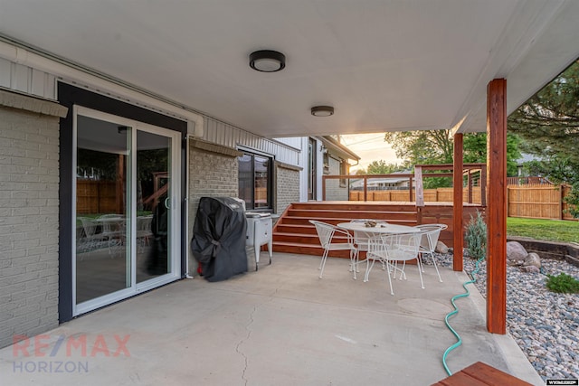 patio terrace at dusk featuring area for grilling