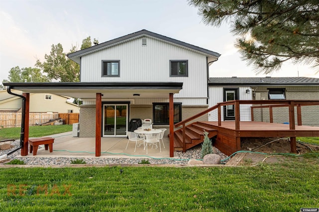 back of house with a lawn, a patio area, and a deck