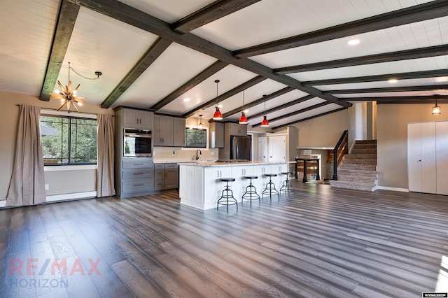 kitchen with a kitchen breakfast bar, a kitchen island, decorative light fixtures, and appliances with stainless steel finishes