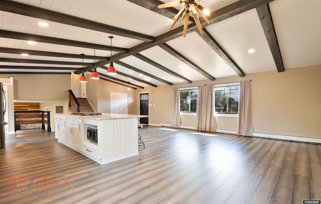 kitchen with a center island, hanging light fixtures, vaulted ceiling with beams, hardwood / wood-style floors, and white cabinets