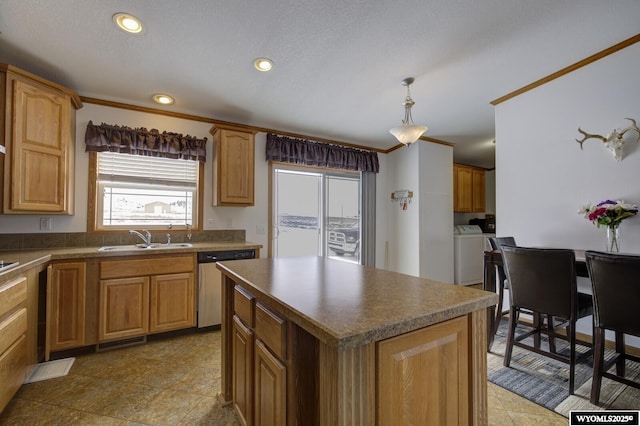 kitchen with a kitchen island, decorative light fixtures, dishwasher, sink, and washing machine and clothes dryer