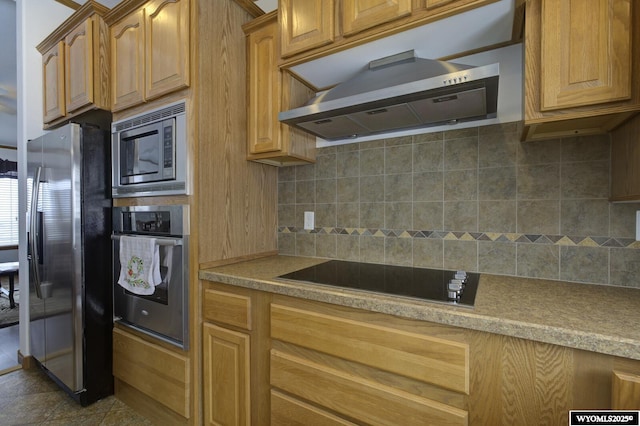 kitchen with tasteful backsplash, appliances with stainless steel finishes, tile patterned floors, and range hood