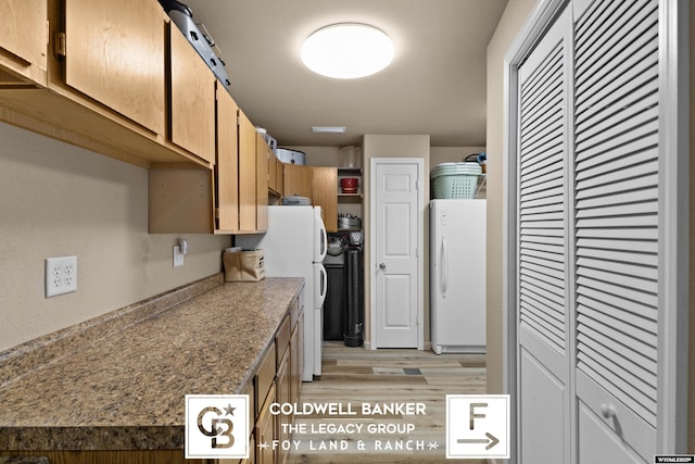 kitchen with light wood-type flooring and white refrigerator