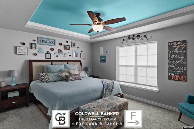 carpeted bedroom featuring a tray ceiling and ceiling fan