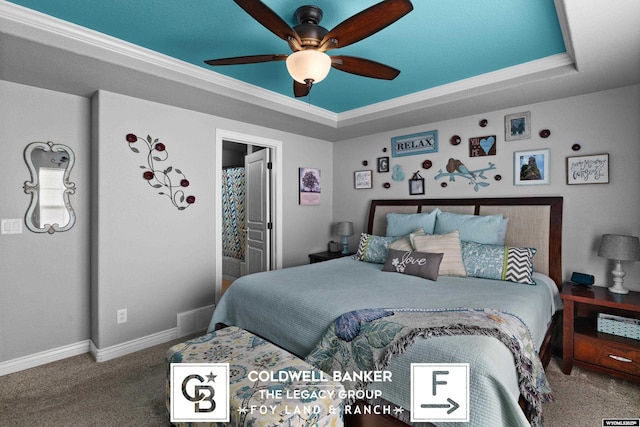 carpeted bedroom with a tray ceiling, ceiling fan, and crown molding