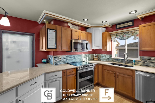 kitchen with white cabinets, sink, stainless steel appliances, and tasteful backsplash