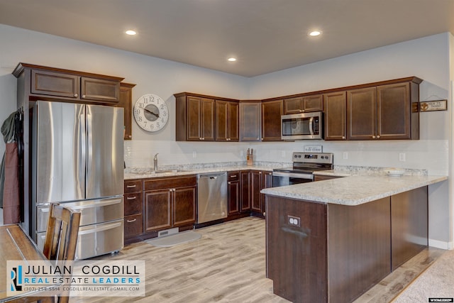 kitchen featuring kitchen peninsula, sink, appliances with stainless steel finishes, light hardwood / wood-style floors, and dark brown cabinetry