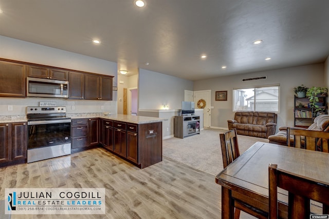 kitchen featuring light carpet, dark brown cabinetry, light stone countertops, kitchen peninsula, and stainless steel appliances