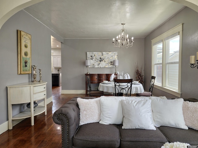 living room with dark hardwood / wood-style floors and an inviting chandelier