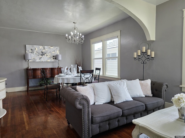 living room with dark wood-type flooring and an inviting chandelier