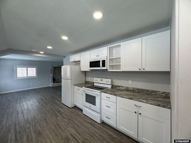 kitchen with a textured ceiling, white cabinetry, dark hardwood / wood-style flooring, and white appliances