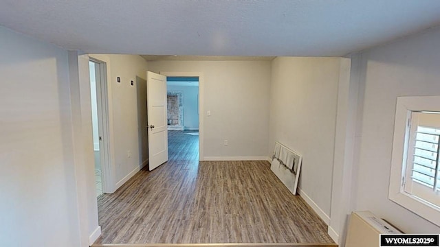 unfurnished room featuring heating unit and light wood-type flooring