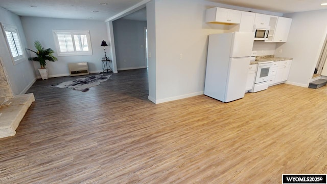 kitchen with white cabinets, light wood-type flooring, and white appliances