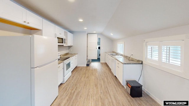 kitchen featuring white cabinetry, sink, light hardwood / wood-style floors, lofted ceiling, and white appliances