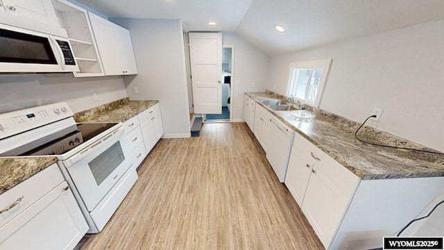 kitchen featuring sink, dark stone counters, vaulted ceiling, white appliances, and white cabinets