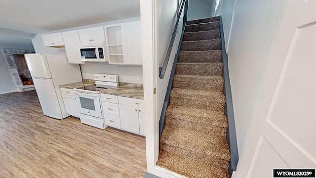 kitchen featuring light wood-type flooring, white appliances, and white cabinetry