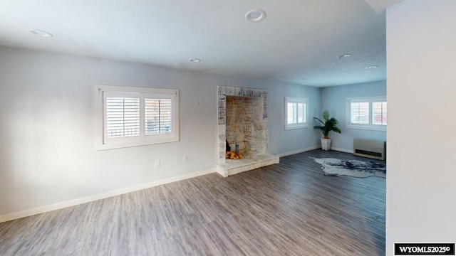 unfurnished living room featuring a fireplace and wood-type flooring