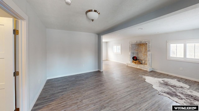 unfurnished living room with a fireplace and dark hardwood / wood-style flooring