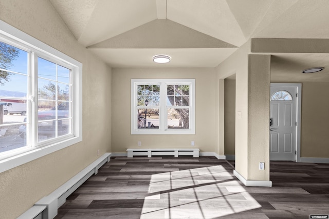 dining area featuring vaulted ceiling, dark hardwood / wood-style flooring, and a baseboard heating unit