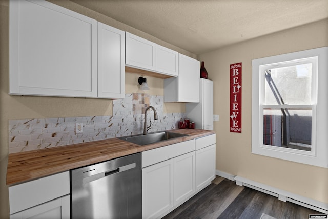 kitchen featuring stainless steel dishwasher, sink, a baseboard radiator, white cabinets, and butcher block countertops