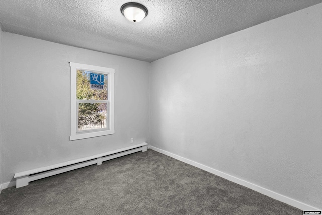 spare room with baseboard heating, a textured ceiling, and dark colored carpet