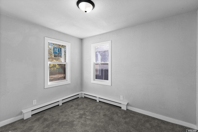 carpeted empty room featuring baseboard heating