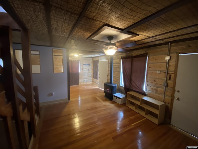 interior space featuring hardwood / wood-style floors, ceiling fan, wooden walls, and brick ceiling