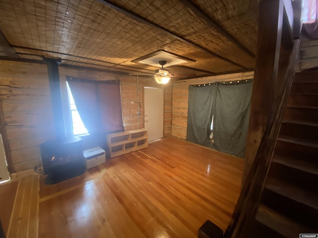 interior space featuring hardwood / wood-style floors, ceiling fan, and wood walls