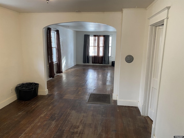 hallway with dark hardwood / wood-style floors and ornamental molding