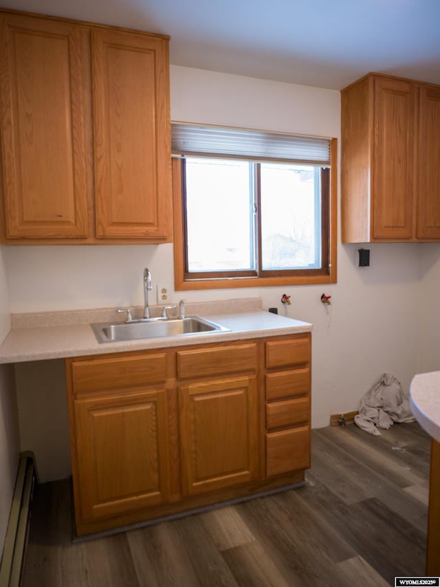 kitchen featuring sink, a baseboard radiator, and dark hardwood / wood-style flooring