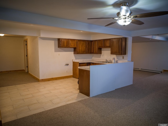 kitchen with ceiling fan, kitchen peninsula, sink, light carpet, and baseboard heating