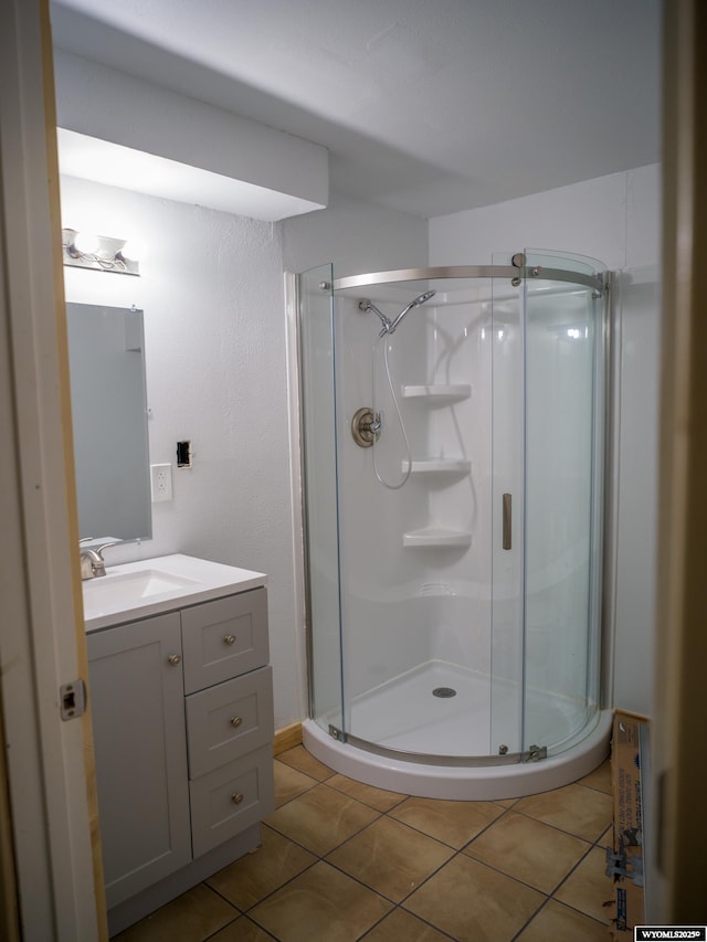 bathroom featuring tile patterned floors, an enclosed shower, and vanity