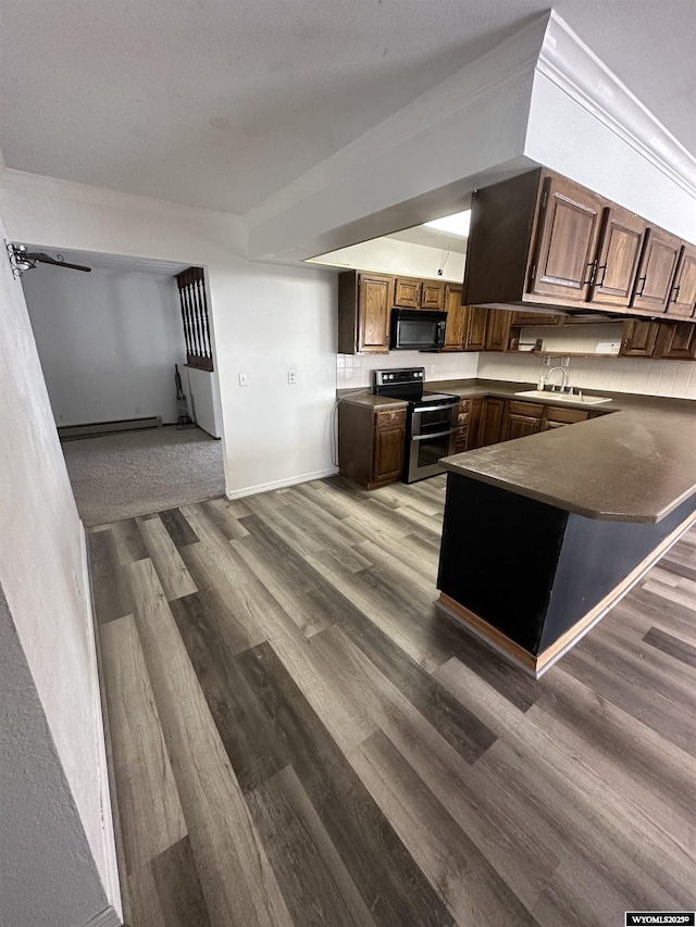 kitchen featuring range with two ovens, sink, ornamental molding, kitchen peninsula, and hardwood / wood-style flooring