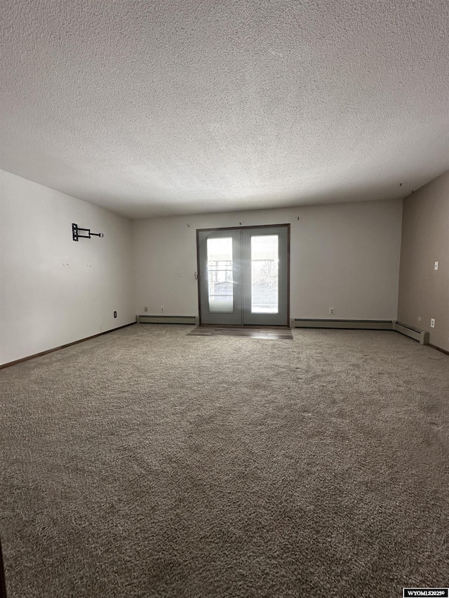 carpeted spare room featuring a baseboard radiator, a textured ceiling, and french doors