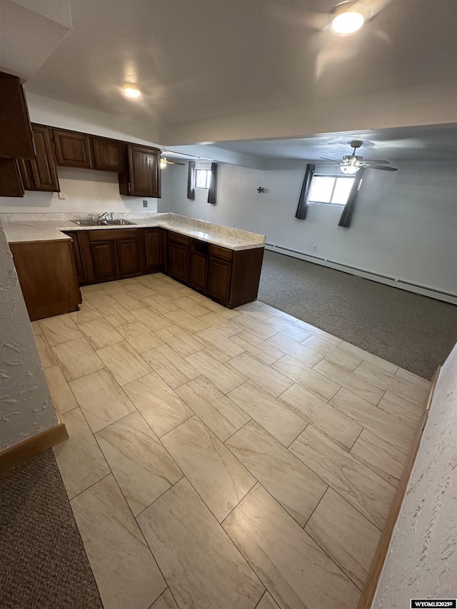 kitchen with ceiling fan, sink, and dark brown cabinetry